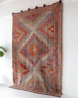 Vintage kilim rug in living room setting, old rug, antique rug, pastel colors, faded colors, Turkish rug, vintage rug, soft rug, Portland, Oregon, rug store, rug shop, local shop, earthy tones, earthy colors, warm colors