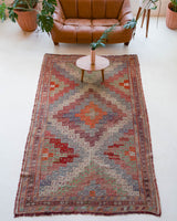 Vintage kilim rug in living room setting, old rug, antique rug, pastel colors, faded colors, Turkish rug, vintage rug, soft rug, Portland, Oregon, rug store, rug shop, local shop, earthy tones, earthy colors, warm colors