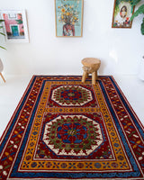 Vintage Turkish rug in a living room setting, pile rug, Turkish rug, vintage rug, portland, rug shop, bright colors, wild shaman, soft rug, bold color, Portland, Oregon, rug store, rug shop, local shop, antique rug