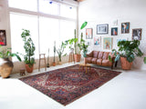 Antique Persian area rug in a living room setting, pile rug, vintage rug, portland, rug shop, bright colors, wild shaman, soft rug, bold color, Portland, Oregon, rug store, rug shop, local shop, antique rug, Persian rug, handmade rug, wool rug, distressed rug