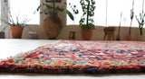 Antique Persian area rug in a living room setting, pile rug, vintage rug, portland, rug shop, bright colors, wild shaman, soft rug, bold color, Portland, Oregon, rug store, rug shop, local shop, antique rug, Persian rug, handmade rug, wool rug, distressed rug
