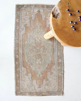Vintage Turkish mini rug in room decor setting, old rug, antique rug, pastel colors, faded colors, Turkish rug, vintage rug, soft rug, Portland, Oregon, rug store, rug shop, local shop
