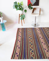 Vintage kilim rug in room decor setting, old rug, antique rug, pastel colors, faded colors, Turkish rug, vintage rug, soft rug, Portland, Oregon, rug store, rug shop, local shop, distressed rug, worn out rug