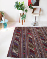 Vintage kilim rug in room decor setting, old rug, antique rug, pastel colors, faded colors, Turkish rug, vintage rug, soft rug, Portland, Oregon, rug store, rug shop, local shop, distressed rug, worn out rug