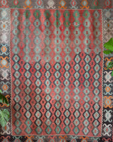 Vintage kilim rug in living room setting, old rug, antique rug, pastel colors, faded colors, Turkish rug, vintage rug, soft rug, Portland, Oregon, rug store, rug shop, local shop, earthy tones, earthy colors, warm colors