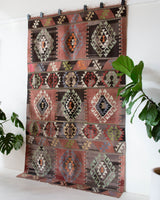 Vintage kilim rug in living room setting, old rug, antique rug, pastel colors, faded colors, Turkish rug, vintage rug, soft rug, Portland, Oregon, rug store, rug shop, local shop, earthy tones, earthy colors, warm colors