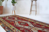 Vintage Turkish runner rug in a living room setting, pile rug, Turkish rug, vintage rug, portland, rug shop, bright colors, wild shaman, soft rug, bold color, Portland, Oregon, rug store, rug shop, local shop, antique rug