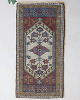 Vintage Turkish mini rug in room decor setting, old rug, antique rug, pastel colors, faded colors, Turkish rug, vintage rug, soft rug, Portland, Oregon, rug store, rug shop, local shop