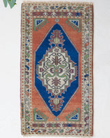 Vintage Turkish mini rug in room decor setting, old rug, antique rug, pastel colors, faded colors, Turkish rug, vintage rug, soft rug, Portland, Oregon, rug store, rug shop, local shop