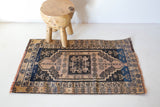 Vintage Turkish mini rug in room decor setting, old rug, antique rug, pastel colors, faded colors, Turkish rug, vintage rug, soft rug, Portland, Oregon, rug store, rug shop, local shop