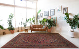 Antique Persian area rug in a living room setting, pile rug, vintage rug, portland, rug shop, bright colors, wild shaman, soft rug, bold color, Portland, Oregon, rug store, rug shop, local shop, antique rug, Persian rug, handmade rug, wool rug