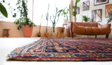 Antique Persian area rug in a living room setting, pile rug, vintage rug, portland, rug shop, bright colors, wild shaman, soft rug, bold color, Portland, Oregon, rug store, rug shop, local shop, antique rug, Persian rug, handmade rug, wool rug