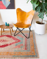 Area rug in a living room setting, pile rug, Turkish rug, old rug, antique rug, pastel colors, faded colors, Turkish rug, vintage rug, soft rug, Portland, Oregon, rug store, rug shop, local shop, distressed rug, worn out rug
