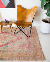 Area rug in a living room setting, pile rug, Turkish rug, old rug, antique rug, pastel colors, faded colors, Turkish rug, vintage rug, soft rug, Portland, Oregon, rug store, rug shop, local shop, distressed rug, worn out rug