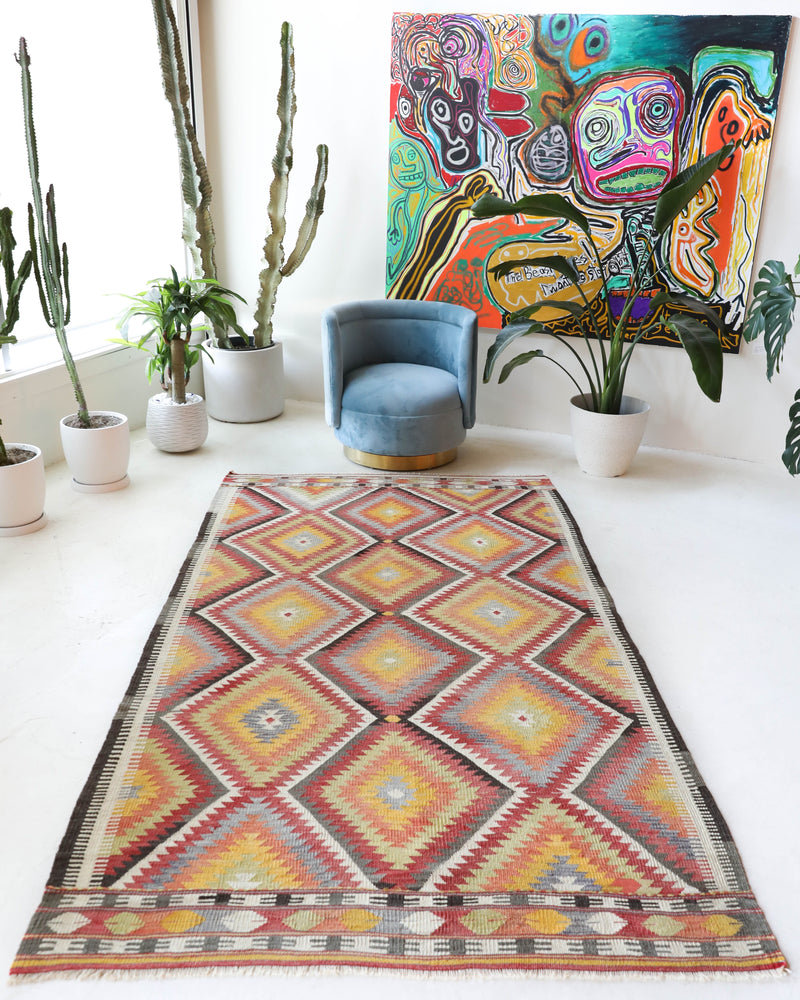 Vintage kilim rug in living room setting, old rug, antique rug, pastel colors, faded colors, Turkish rug, vintage rug, soft rug, Portland, Oregon, rug store, rug shop, local shop, earthy tones, earthy colors, warm colors