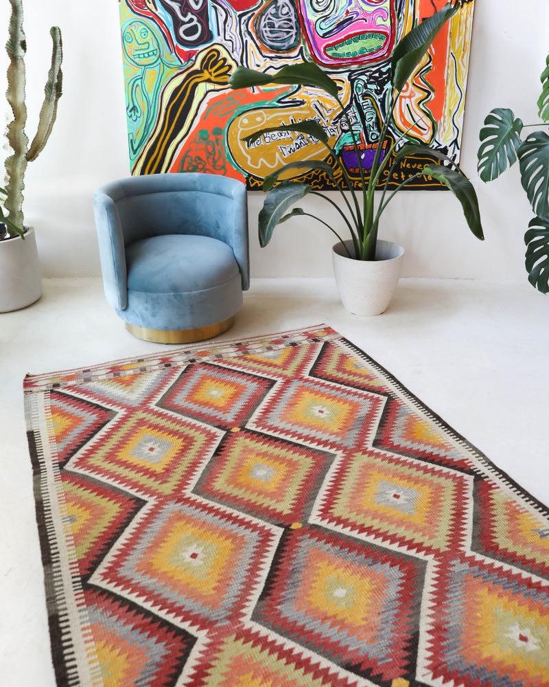 Vintage kilim rug in living room setting, old rug, antique rug, pastel colors, faded colors, Turkish rug, vintage rug, soft rug, Portland, Oregon, rug store, rug shop, local shop, earthy tones, earthy colors, warm colors