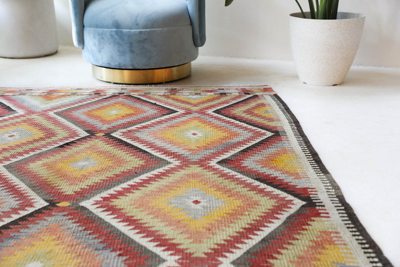 Vintage kilim rug in living room setting, old rug, antique rug, pastel colors, faded colors, Turkish rug, vintage rug, soft rug, Portland, Oregon, rug store, rug shop, local shop, earthy tones, earthy colors, warm colors