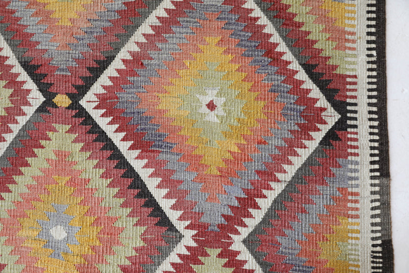 Vintage kilim rug in living room setting, old rug, antique rug, pastel colors, faded colors, Turkish rug, vintage rug, soft rug, Portland, Oregon, rug store, rug shop, local shop, earthy tones, earthy colors, warm colors