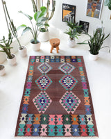 Vintage kilim rug in living room setting, old rug, antique rug, pastel colors, faded colors, Turkish rug, vintage rug, soft rug, Portland, Oregon, rug store, rug shop, local shop, earthy tones, earthy colors, warm colors