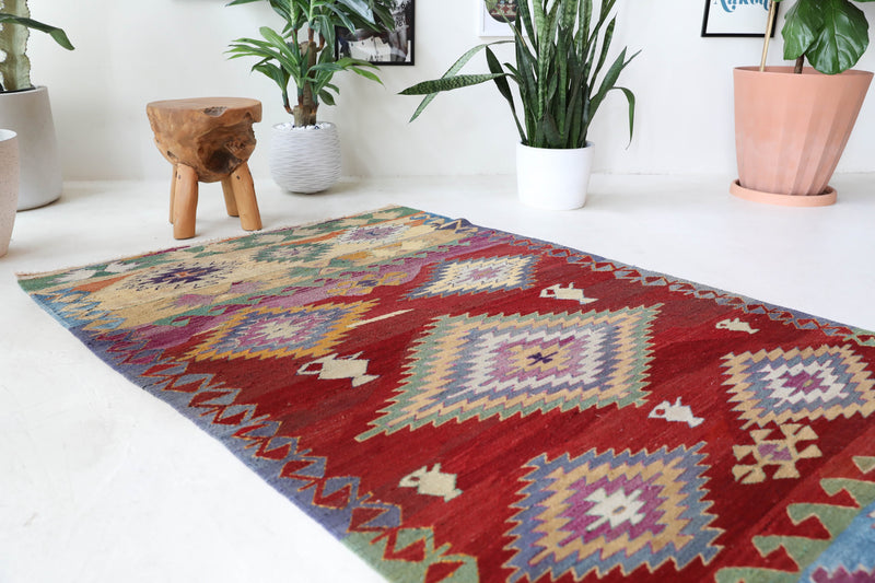 Vintage kilim rug in room decor setting, old rug, antique rug, pastel colors, faded colors, Turkish rug, vintage rug, soft rug, Portland, Oregon, rug store, rug shop, local shop, bold colors, bright colors, faded colors