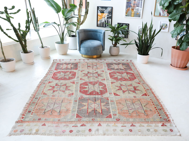 Vintage kilim rug in living room setting, old rug, antique rug, pastel colors, faded colors, Turkish rug, vintage rug, soft rug, Portland, Oregon, rug store, rug shop, local shop, earthy tones, earthy colors, warm colors