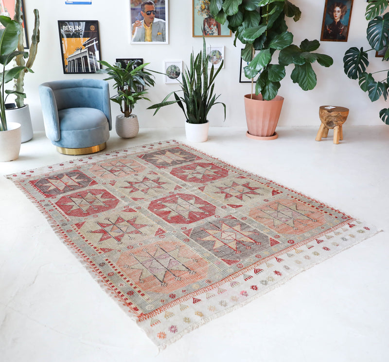 Vintage kilim rug in living room setting, old rug, antique rug, pastel colors, faded colors, Turkish rug, vintage rug, soft rug, Portland, Oregon, rug store, rug shop, local shop, earthy tones, earthy colors, warm colors