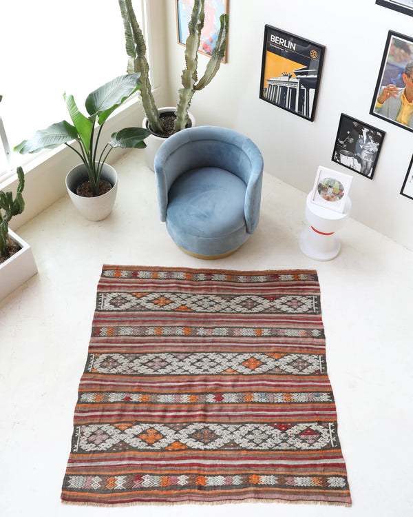 Vintage kilim rug in living room setting, old rug, antique rug, pastel colors, faded colors, Turkish rug, vintage rug, soft rug, Portland, Oregon, rug store, rug shop, local shop, earthy tones, earthy colors, warm colors