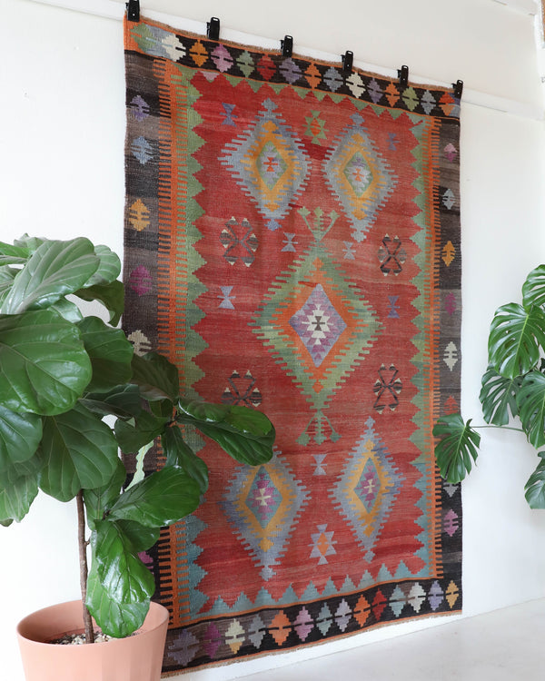 Vintage kilim rug in living room setting, old rug, antique rug, pastel colors, faded colors, Turkish rug, vintage rug, soft rug, Portland, Oregon, rug store, rug shop, local shop, earthy tones, earthy colors, warm colors