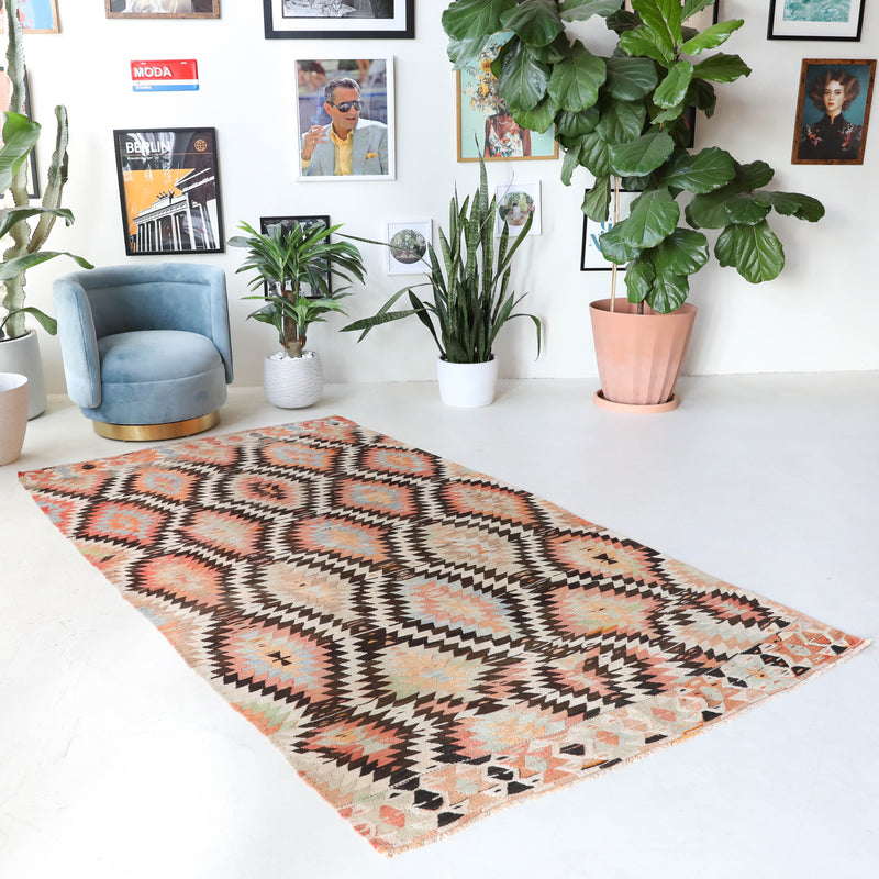 Vintage kilim rug in living room setting, old rug, antique rug, pastel colors, faded colors, Turkish rug, vintage rug, soft rug, Portland, Oregon, rug store, rug shop, local shop, earthy tones, earthy colors, warm colors