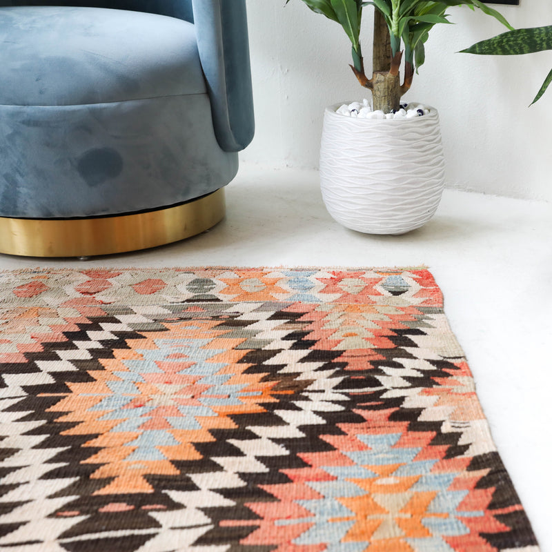 Vintage kilim rug in living room setting, old rug, antique rug, pastel colors, faded colors, Turkish rug, vintage rug, soft rug, Portland, Oregon, rug store, rug shop, local shop, earthy tones, earthy colors, warm colors