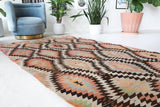 Vintage kilim rug in living room setting, old rug, antique rug, pastel colors, faded colors, Turkish rug, vintage rug, soft rug, Portland, Oregon, rug store, rug shop, local shop, earthy tones, earthy colors, warm colors