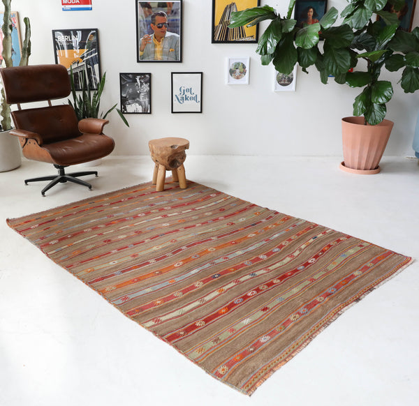 Vintage kilim rug in living room setting, old rug, antique rug, pastel colors, faded colors, Turkish rug, vintage rug, soft rug, Portland, Oregon, rug store, rug shop, local shop, earthy tones, earthy colors, warm colors