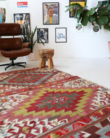 Vintage kilim rug in living room setting, old rug, antique rug, pastel colors, faded colors, Turkish rug, vintage rug, soft rug, Portland, Oregon, rug store, rug shop, local shop, earthy tones, earthy colors, warm colors