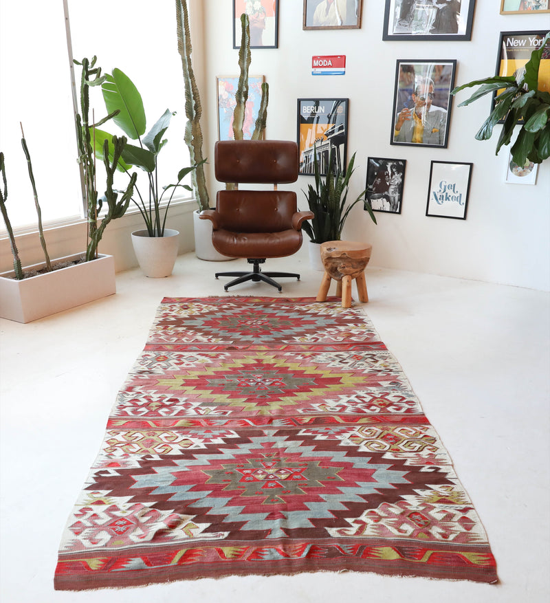 Vintage kilim rug in living room setting, old rug, antique rug, pastel colors, faded colors, Turkish rug, vintage rug, soft rug, Portland, Oregon, rug store, rug shop, local shop, earthy tones, earthy colors, warm colors