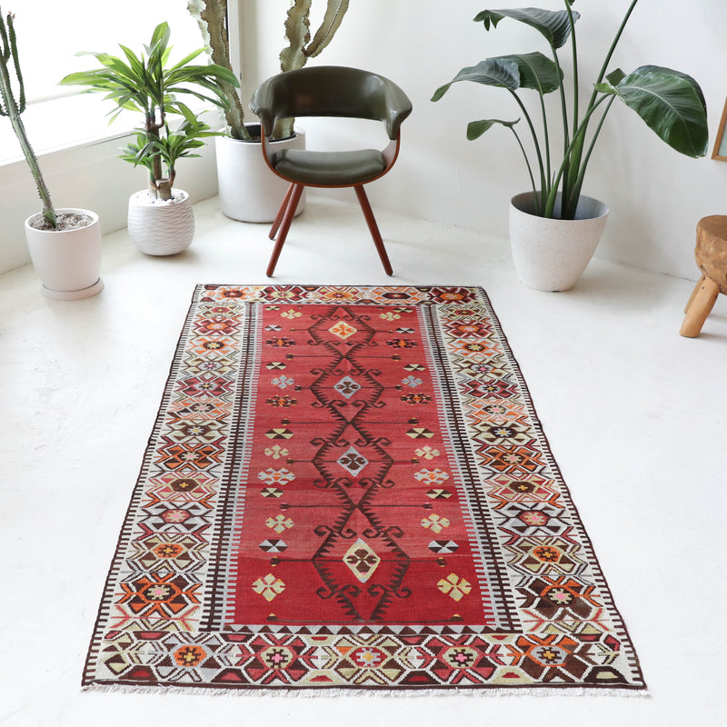 Vintage kilim rug in room decor setting, old rug, antique rug, pastel colors, faded colors, Turkish rug, vintage rug, soft rug, Portland, Oregon, rug store, rug shop, local shop,  antique kilim rug, bold colors, bright colors, faded colors