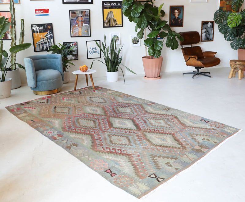 Vintage kilim rug in living room setting, old rug, antique rug, pastel colors, faded colors, Turkish rug, vintage rug, soft rug, Portland, Oregon, rug store, rug shop, local shop, earthy tones, earthy colors, warm colors