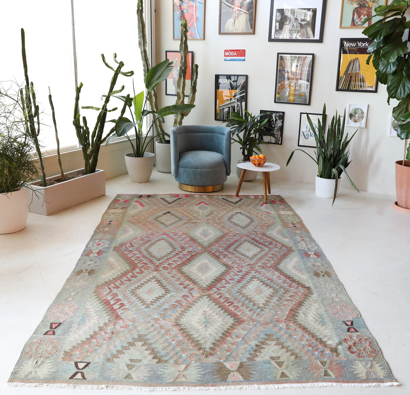 Vintage kilim rug in living room setting, old rug, antique rug, pastel colors, faded colors, Turkish rug, vintage rug, soft rug, Portland, Oregon, rug store, rug shop, local shop, earthy tones, earthy colors, warm colors