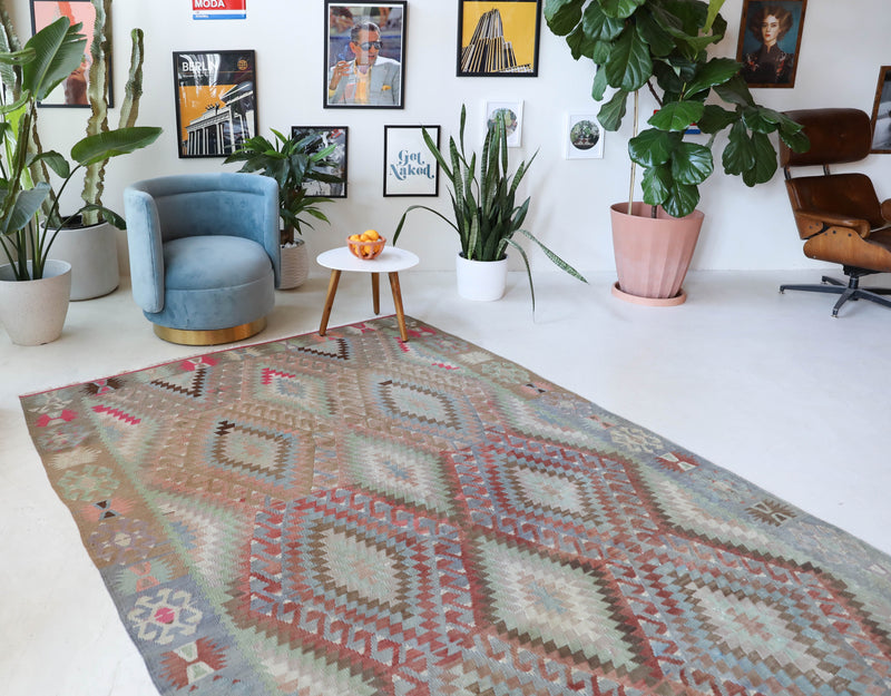 Vintage kilim rug in living room setting, old rug, antique rug, pastel colors, faded colors, Turkish rug, vintage rug, soft rug, Portland, Oregon, rug store, rug shop, local shop, earthy tones, earthy colors, warm colors