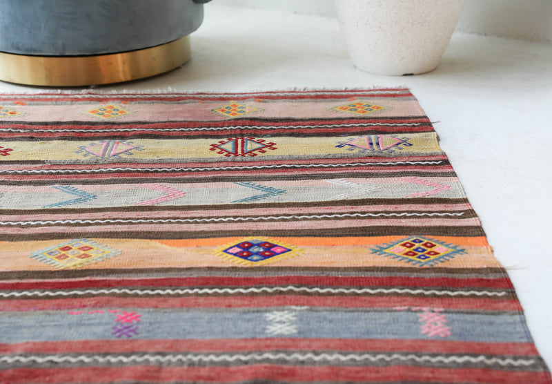 Vintage kilim rug in room decor setting, old rug, antique rug, pastel colors, faded colors, Turkish rug, vintage rug, soft rug, Portland, Oregon, rug store, rug shop, local shop,  antique kilim rug, bold colors, bright colors, faded colors