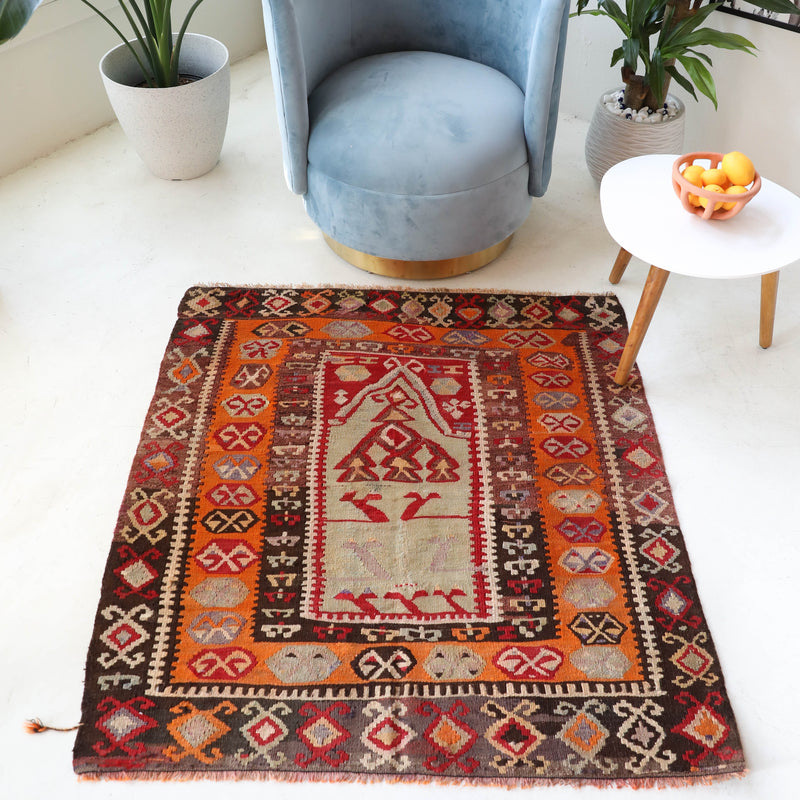 Vintage kilim rug in living room setting, old rug, antique rug, pastel colors, faded colors, Turkish rug, vintage rug, soft rug, Portland, Oregon, rug store, rug shop, local shop, earthy tones, earthy colors, warm colors