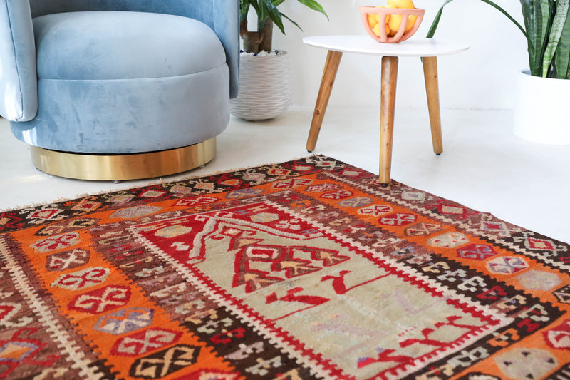 Vintage kilim rug in living room setting, old rug, antique rug, pastel colors, faded colors, Turkish rug, vintage rug, soft rug, Portland, Oregon, rug store, rug shop, local shop, earthy tones, earthy colors, warm colors