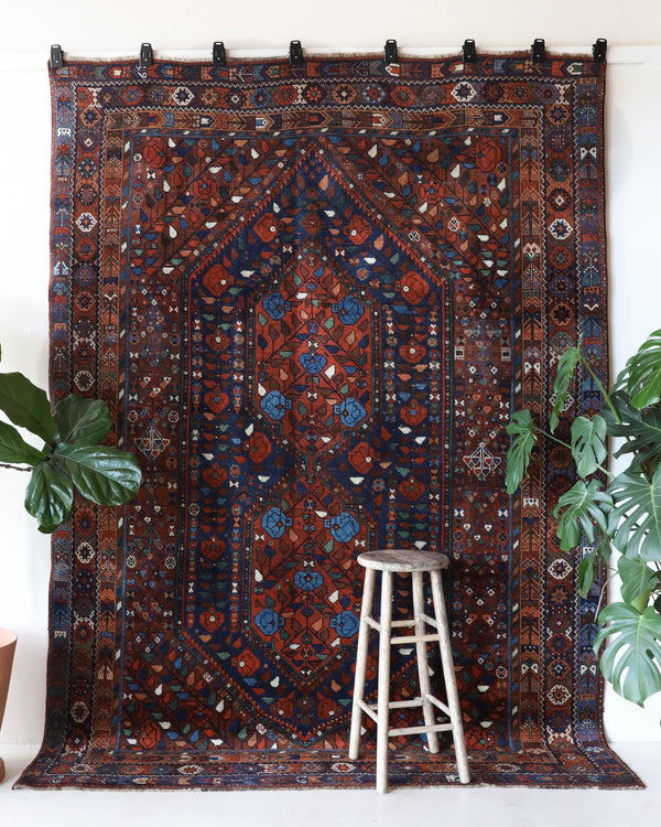 Antique Persian area rug in a living room setting, pile rug, vintage rug, portland, rug shop, bright colors, wild shaman, soft rug, bold color, Portland, Oregon, rug store, rug shop, local shop, antique rug, Persian rug, handmade rug, wool rug, distressed rug