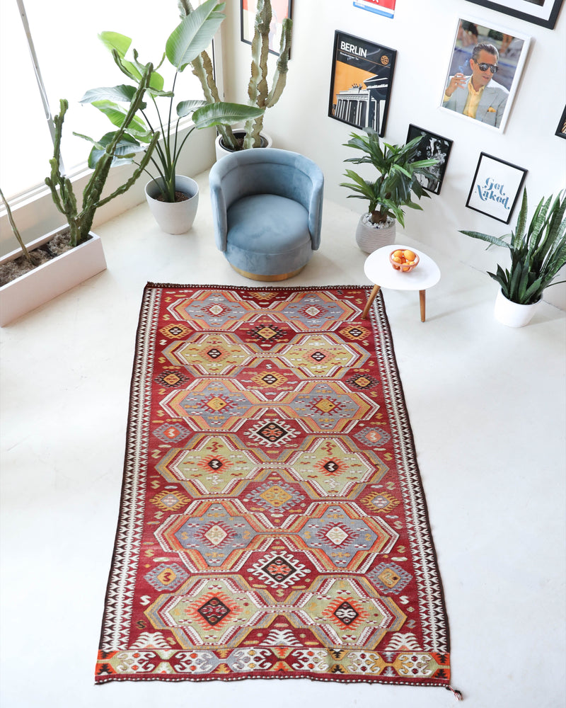 Vintage kilim rug in living room setting, old rug, antique rug, pastel colors, faded colors, Turkish rug, vintage rug, soft rug, Portland, Oregon, rug store, rug shop, local shop, earthy tones, earthy colors, warm colors