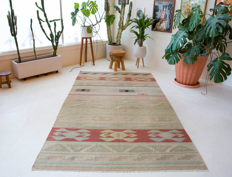 Vintage kilim rug in living room setting, old rug, antique rug, pastel colors, faded colors, Turkish rug, vintage rug, soft rug, Portland, Oregon, rug store, rug shop, local shop, earthy tones, earthy colors, warm colors, flat weave