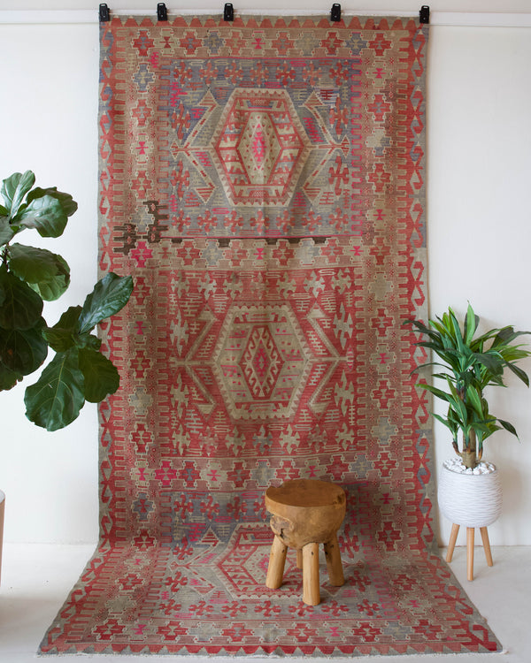 Vintage kilim rug in living room setting, old rug, antique rug, pastel colors, faded colors, Turkish rug, vintage rug, soft rug, Portland, Oregon, rug store, rug shop, local shop, earthy tones, earthy colors, warm colors