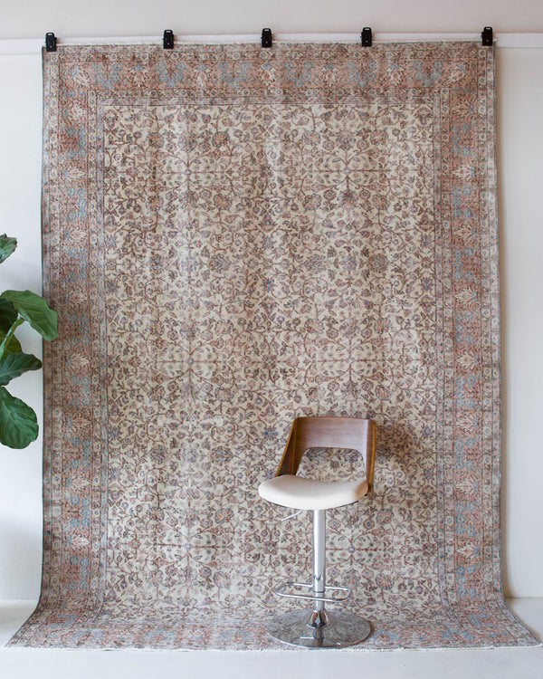 Area rug in a living room setting, pile rug, Turkish rug, old rug, antique rug, pastel colors, faded colors, Turkish rug, vintage rug, soft rug, Portland, Oregon, rug store, rug shop, local shop, distressed rug, worn out rug