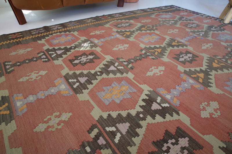 Vintage kilim rug in room decor setting, old rug, antique rug, pastel colors, faded colors, Turkish rug, vintage rug, soft rug, Portland, Oregon, rug store, rug shop, local shop, distressed rug, worn out rug