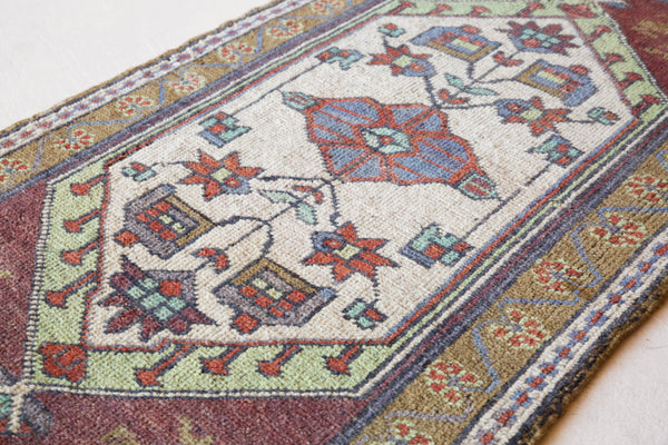 Vintage Turkish mini rug in room decor setting, old rug, antique rug, pastel colors, faded colors, Turkish rug, vintage rug, soft rug, Portland, Oregon, rug store, rug shop, local shop