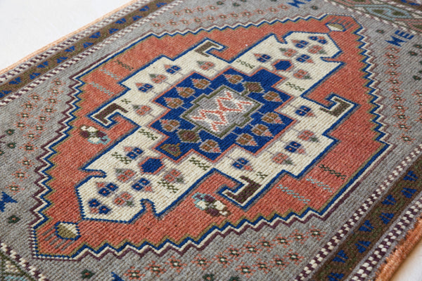 Vintage Turkish mini rug in room decor setting, old rug, antique rug, pastel colors, faded colors, Turkish rug, vintage rug, soft rug, Portland, Oregon, rug store, rug shop, local shop
