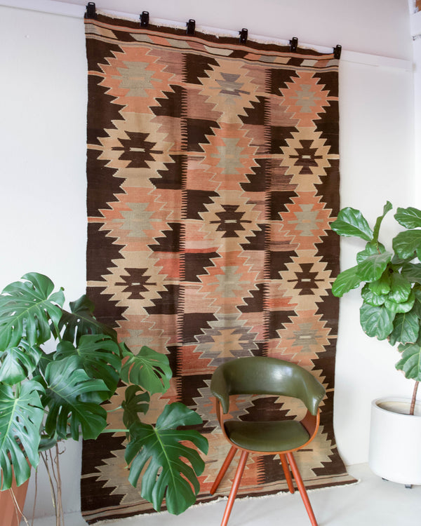 Vintage kilim rug in living room setting, old rug, antique rug, pastel colors, faded colors, Turkish rug, vintage rug, soft rug, Portland, Oregon, rug store, rug shop, local shop, earthy tones, earthy colors, warm colors